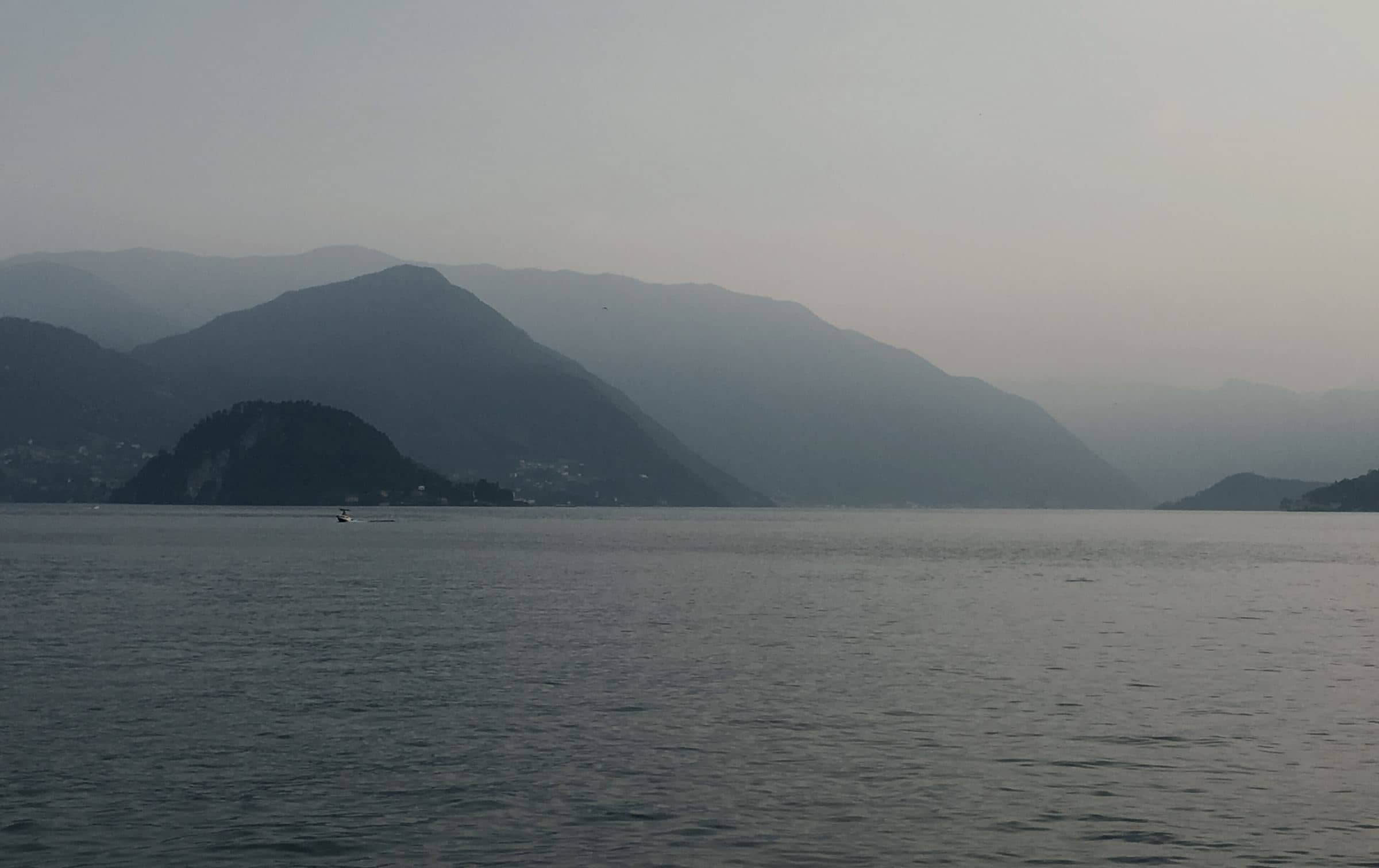 Lake Como at dawn, mountains layered in mist
